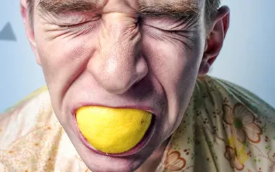 foto di persona che soffre con una buccia di limone in bocca