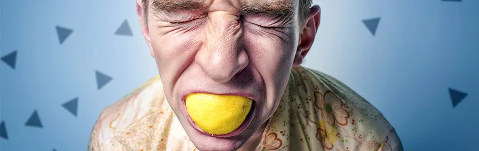 foto di persona che soffre con una buccia di limone in bocca